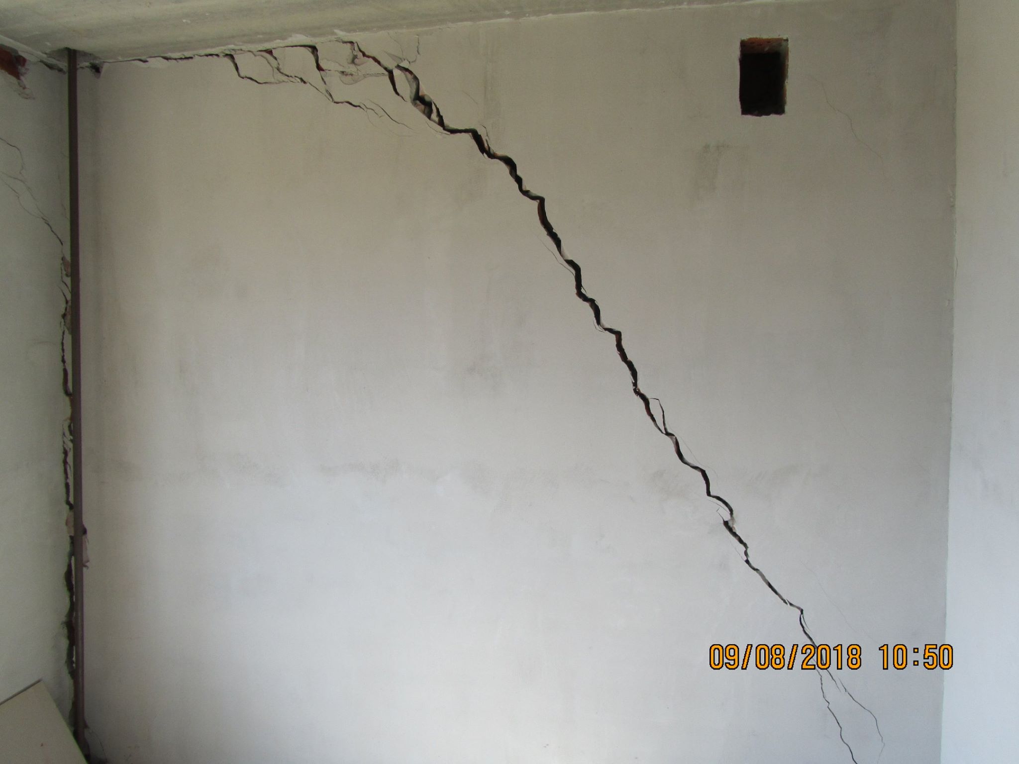 На стене появились трещины. Трещины в перегородках. Сквозная трещина в стене. Усадочные трещины в стенах. Трещины на стенах в новостройке.